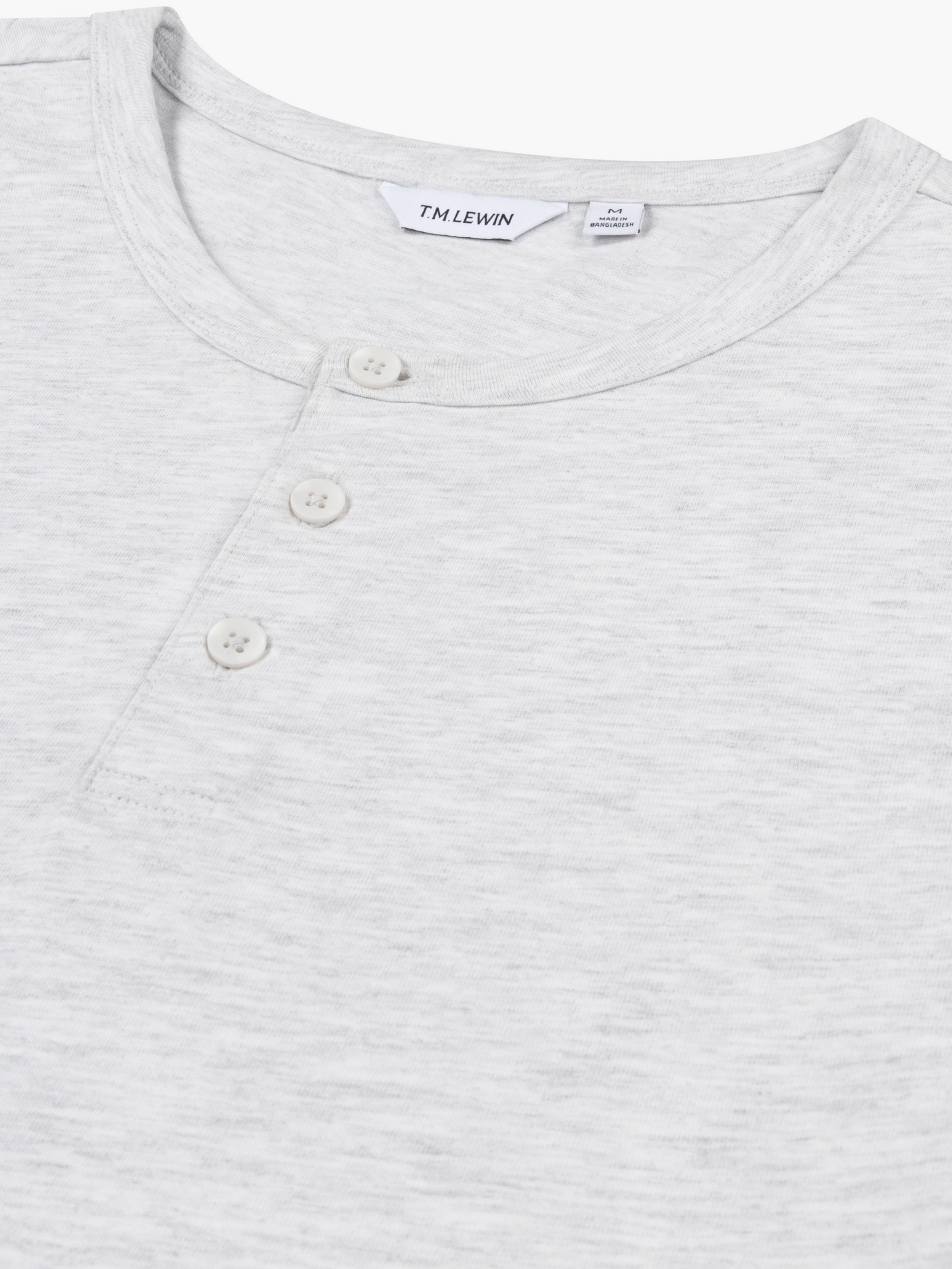 Close-up shot of the placket buttons on a light grey Henley shirt's neckline