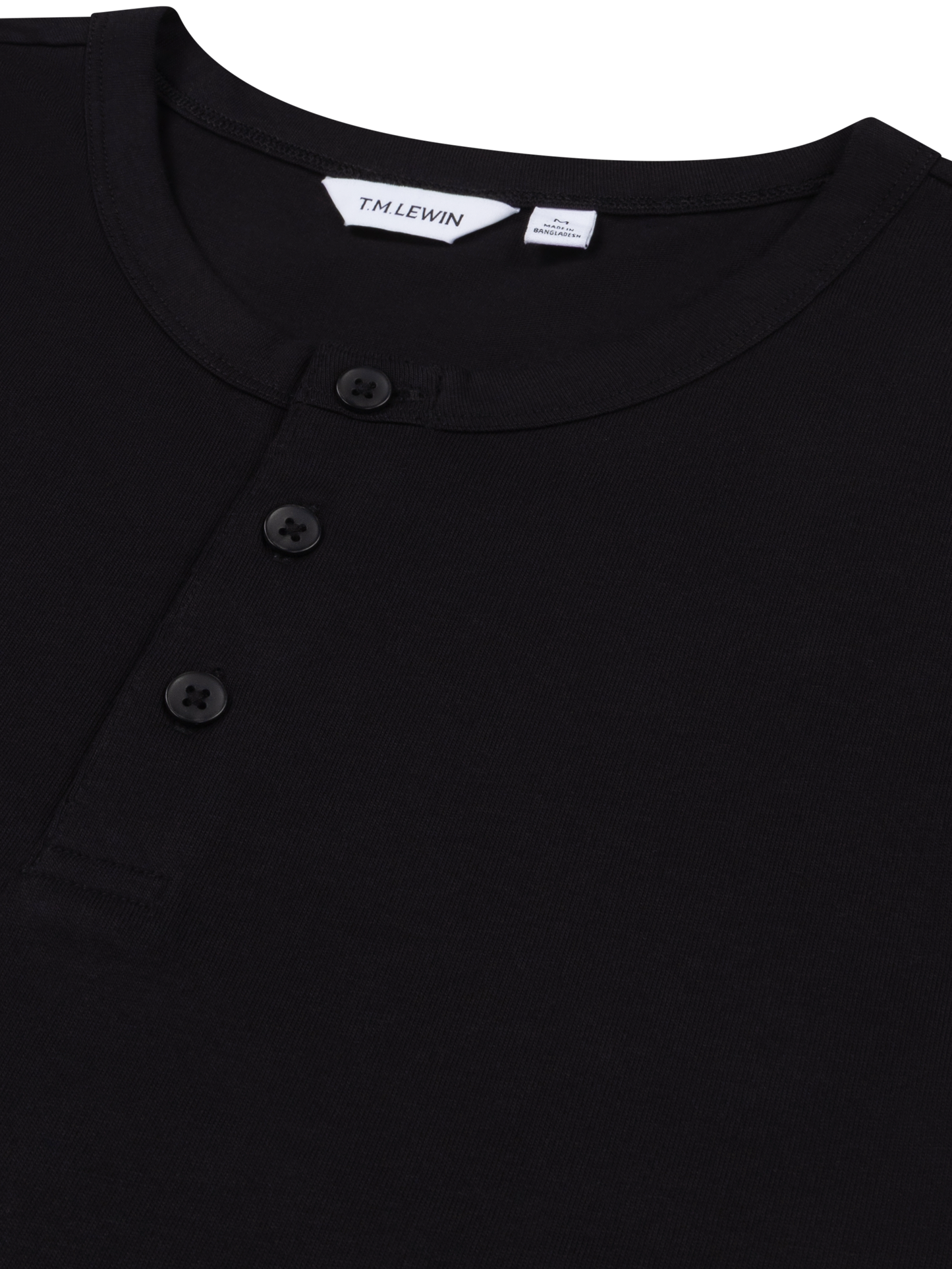 Close-up shot of the placket buttons on a black Henley shirt's neckline